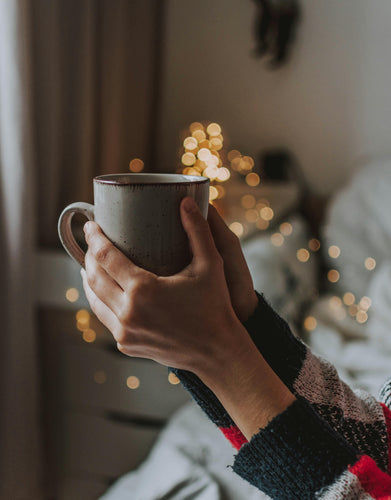 Hands holding a warm mug, evoking a cozy and relaxing hygge atmosphere.