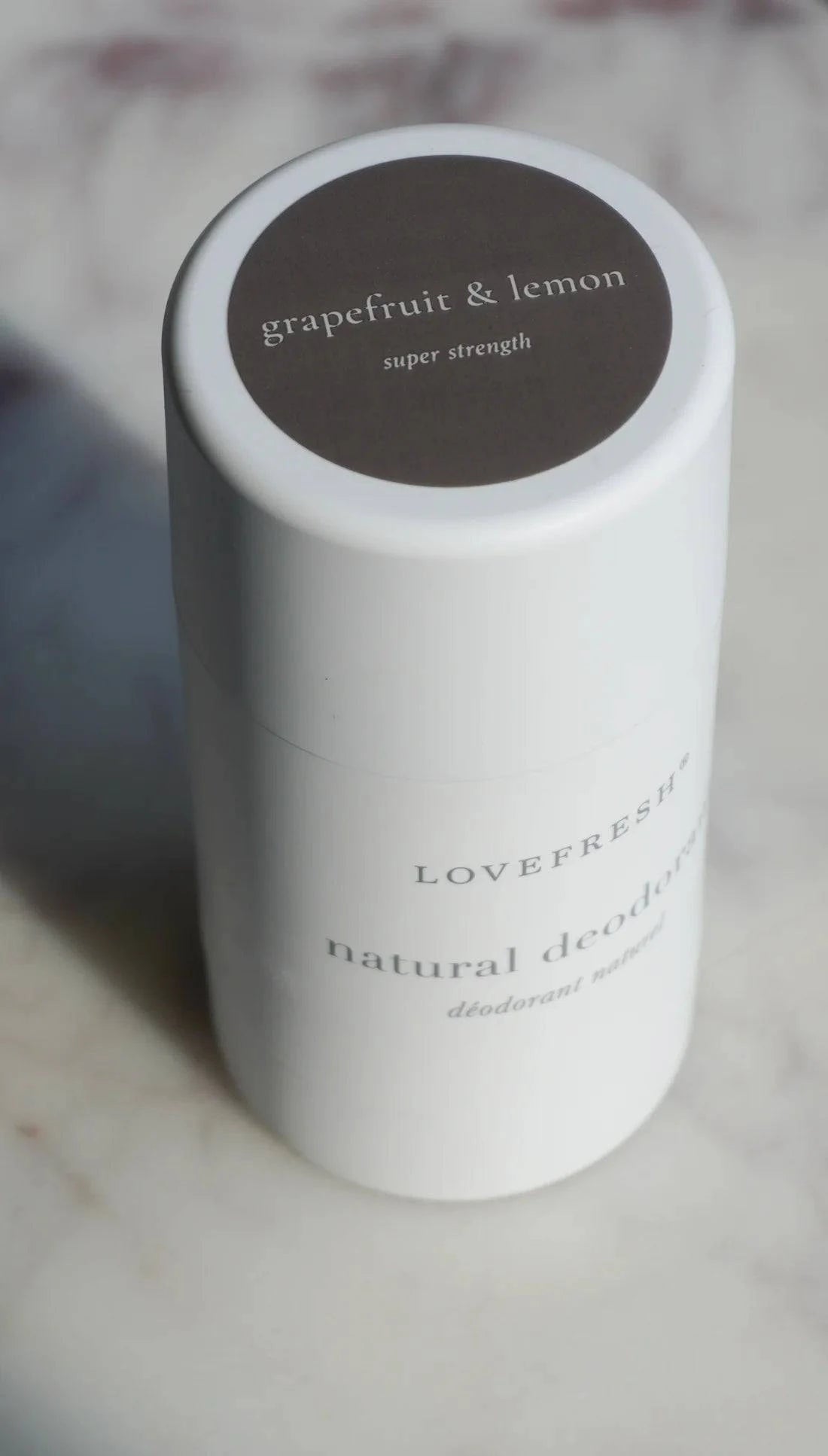 A close-up of Lovefresh Grapefruit & Lemon Natural Deodorant, highlighting its smooth texture and vibrant, citrus-inspired packaging.