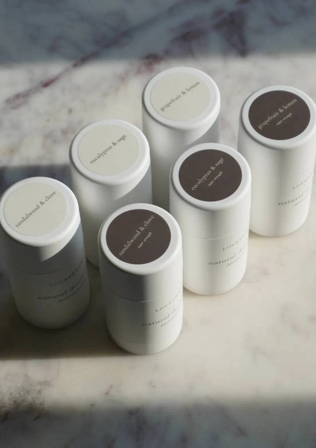 A lineup of Lovefresh Natural Deodorants in various scents, elegantly arranged to showcase their sleek packaging and clean, natural design.