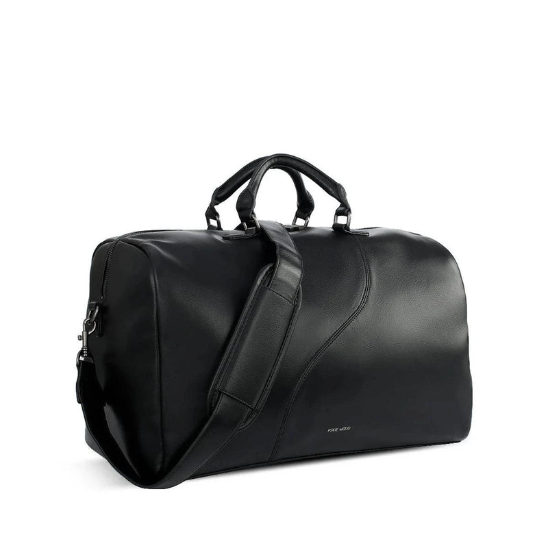 Angle view of the black pixie mood vegan handbag called the Juliet Weekender, showing off its handle detail and shoulder strap.