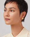 Art Heart Button Earrings by Jenny Bird in high-polish gold, worn by a model for an elegant look