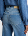 Back view of ultra high-rise, wide-leg denim with subtle whiskering and fading along the thighs.