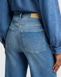 Back view of ultra high-rise, wide-leg denim with subtle whiskering and fading along the thighs.