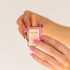 Hand holding another pink Bkind Nail Polish bottle, offering a vibrant and playful shade for your nails.