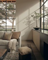 Cozy family room with couch and rug and warm lighting from Call It Home by Amber Lewis.