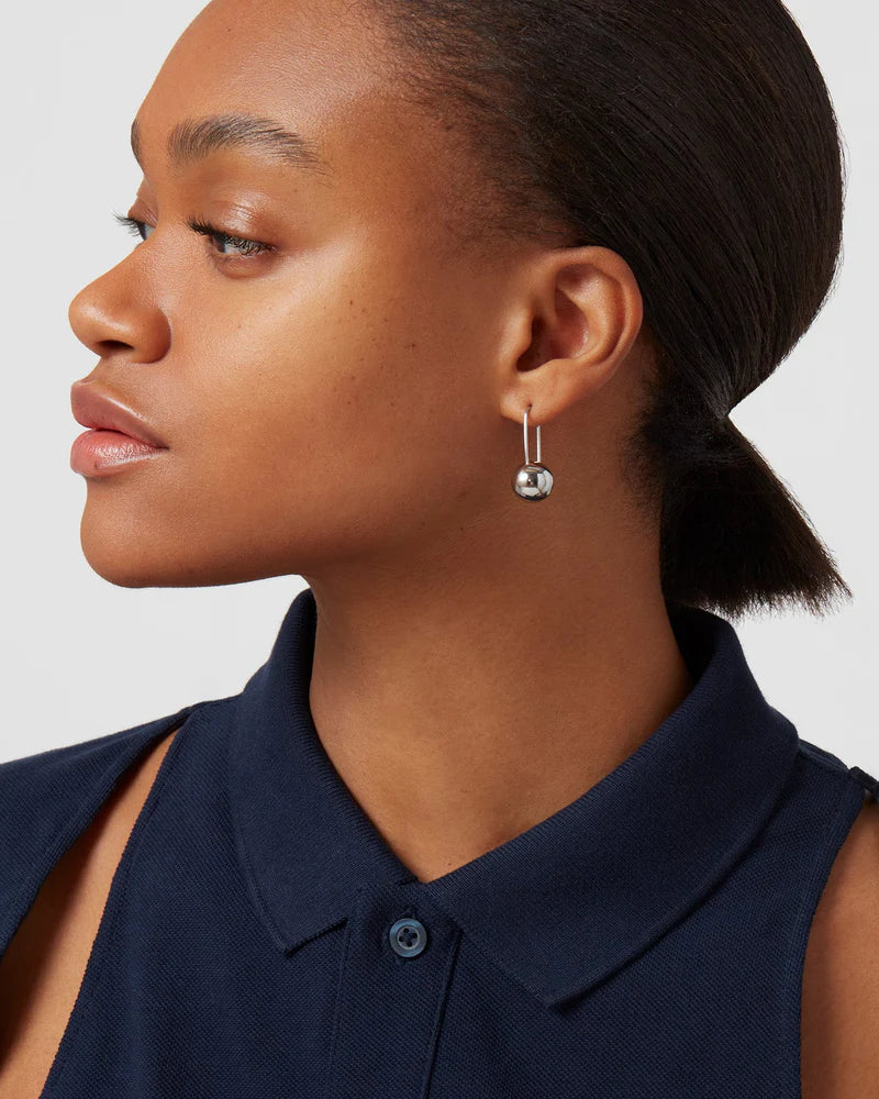 Model wearing Celeste Earrings in high-polish silver, a modern and elegant statement piece.