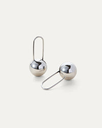 Celeste Earrings in silver displayed on a white background, highlighting their modern drop design.