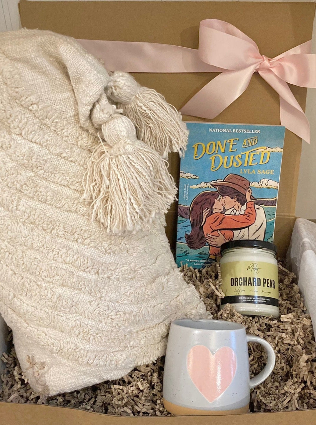 Cozy Night In Kit featuring a mug, book, throw blanket, candle, and a beautifully wrapped gift box from Lemonberry, Aurora, ON.