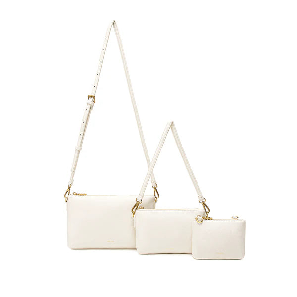 The Drea Pouches Set in white, displayed with three different-sized pouches and two detachable straps—one short and one adjustable long strap—for versatile carrying options.