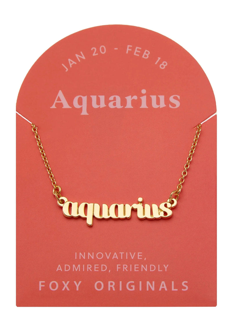 Foxy Originals Aquarius Zodiac Necklace on its display card, featuring a gold script-style pendant and elegant packaging.