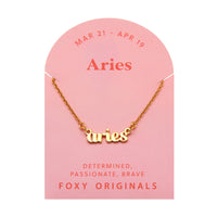 Foxy Originals Aries Zodiac Necklace on its display card, showcasing a gold script-style pendant with elegant packaging.