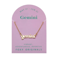 Foxy Originals Gemini Zodiac Necklace on its display card, featuring a gold script-style pendant with stylish packaging.