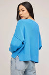 Back view of the Echo Sweater in Capri blue, highlighting the oversized fit and side slits.