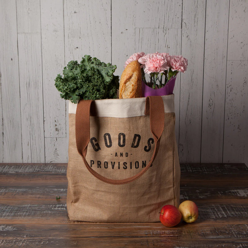 Goods & Provisions Market Tote by Now Designs sitting on a table filled with groceries, demonstrating its capacity and eco-conscious design.