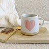 Heart-shaped mug displayed on a cutting board, adding a rustic touch to your kitchen setup