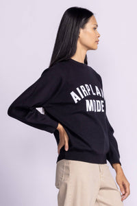 Side view of the Pink Martini Catching Flights Sweater, highlighting the relaxed fit and ribbed hem.