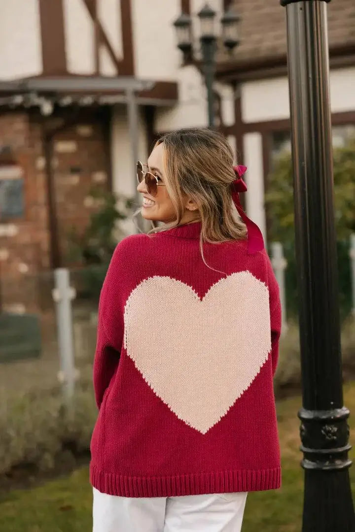 Back view of the Smash + Tess Big Heart Cardigan in red, featuring a large pink heart design. Cozy knit with a relaxed fit, available at Lemonberry, Aurora, ON