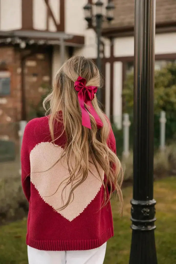 Back view of the Smash + Tess Big Heart Cardigan in red, highlighting the oversized pink heart design and cozy knit fabric. Available at Lemonberry, Aurora, ON.