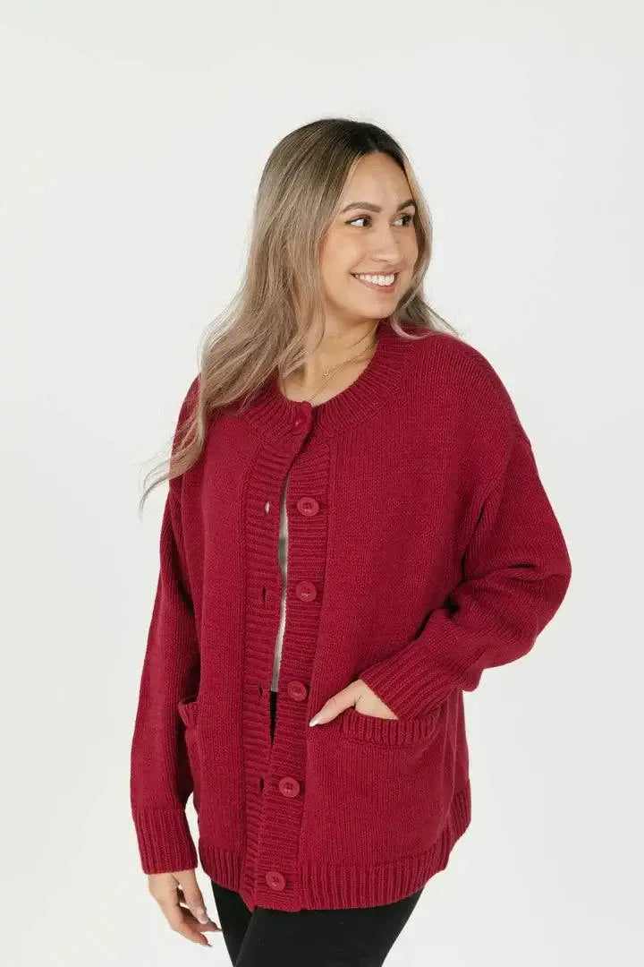 Front angle view of the Smash + Tess Big Heart Cardigan in red, highlighting its relaxed fit, button closure, and soft knit fabric. Available at Lemonberry, Aurora, ON