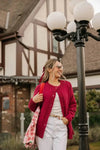 Front view of the Smash + Tess Big Heart Cardigan in red, featuring a relaxed fit, button closure, and front pockets. Model is smiling. Available at Lemonberry, Aurora, ON.