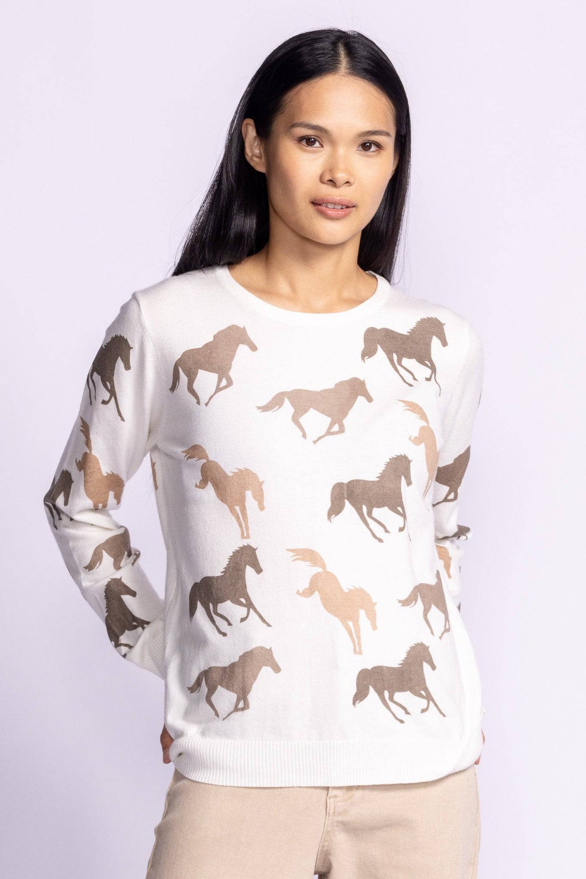 Model wearing the Wild Horses Sweater from the front with arms slightly raised, showcasing the horse print and relaxed fit.