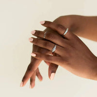 Two hands together, both showing off their nails painted with Bkind Nail Polish, showcasing vibrant, healthy color.