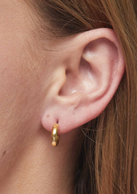 Side view of a model wearing Foxy Originals Petite Hoops in gold, highlighting their bold yet minimal look.