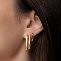 Model wearing Jenny Bird U-Link Earrings in gold, styled for an elegant look with a high polish finish.