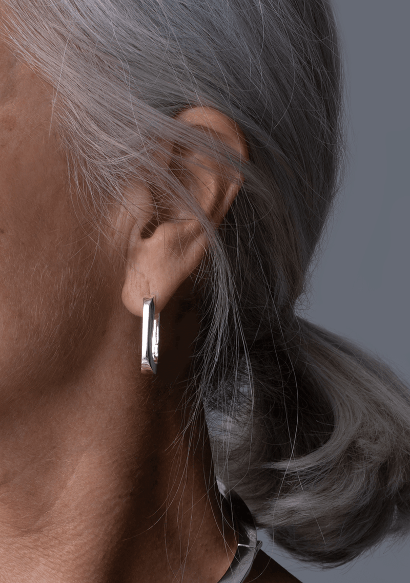 Model wearing Jenny Bird U-Link Earrings in silver, featuring a high polish finish and a modern, custom link design.